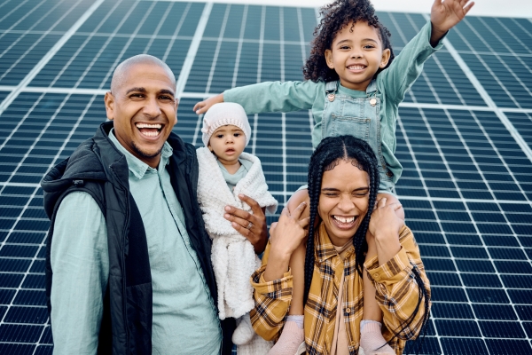 family with solar panels in background