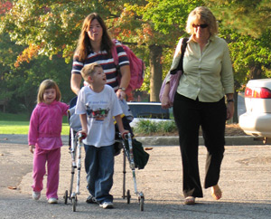 boy using crutches with two women and a girl