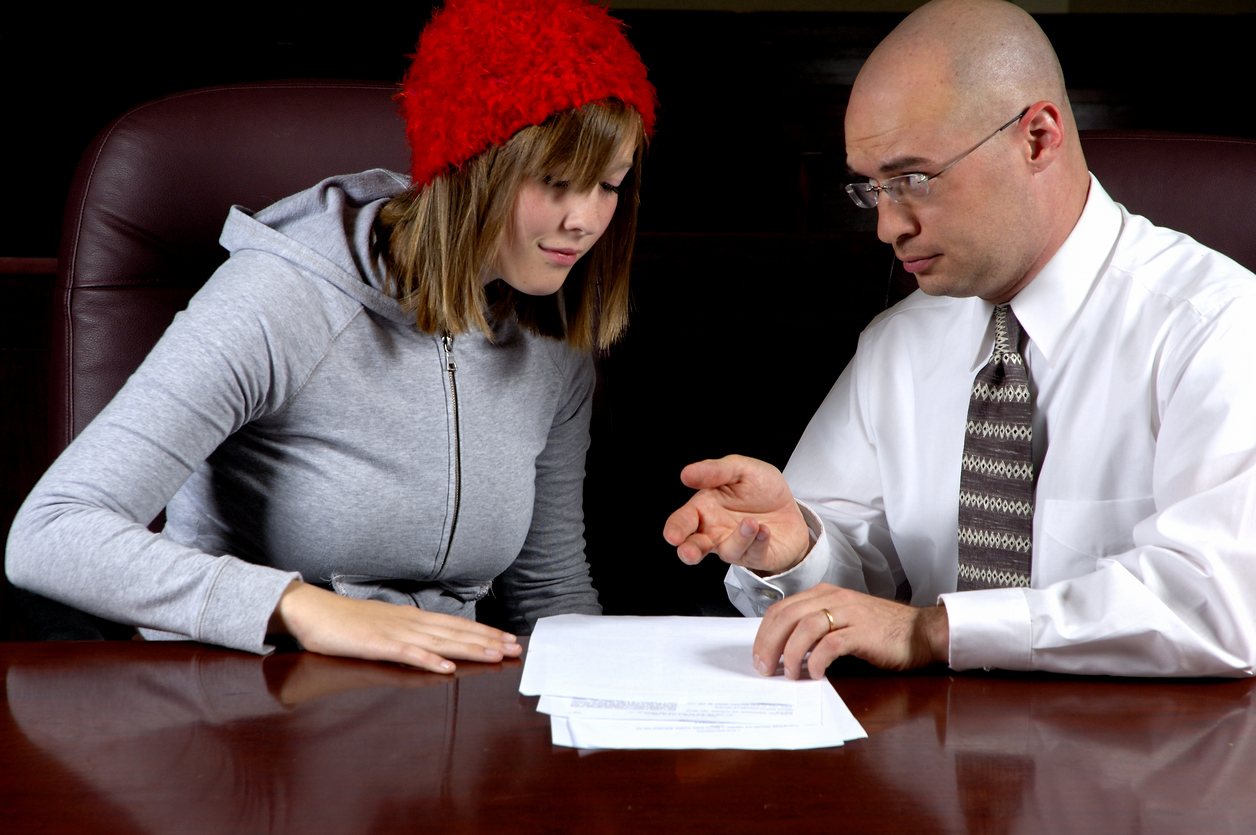 Lawyer helping young adult with paperwork