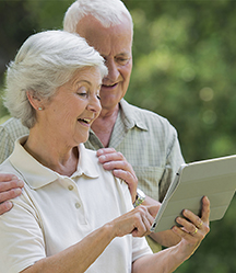 An older couple looking at a tablet screen.