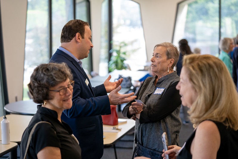 理事主席Friedson在與村莊成員的會面和問候（meet and greet）中與一位居民交談。