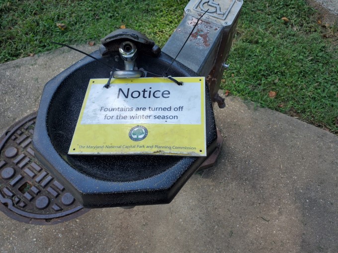 Fuente de agua con la notificación que está fuera de servicio por la temporada.