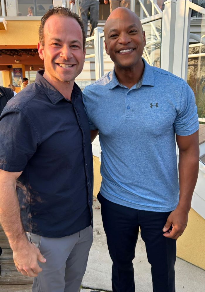 El presidente del Concejo Andrew Friedson y el Gobernador Wes Moore sonriendo para una foto juntos.