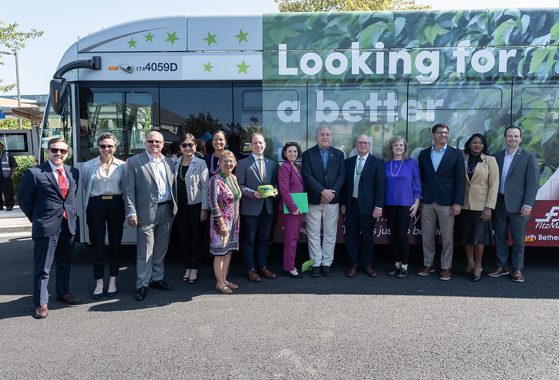 Les dirigeants du comté et de l'État se tiennent devant un bus Ride On extRa emballé.