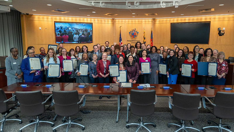 A large group of women and Councilmembers gather in Council chamber for Women’s History Month proclamation.