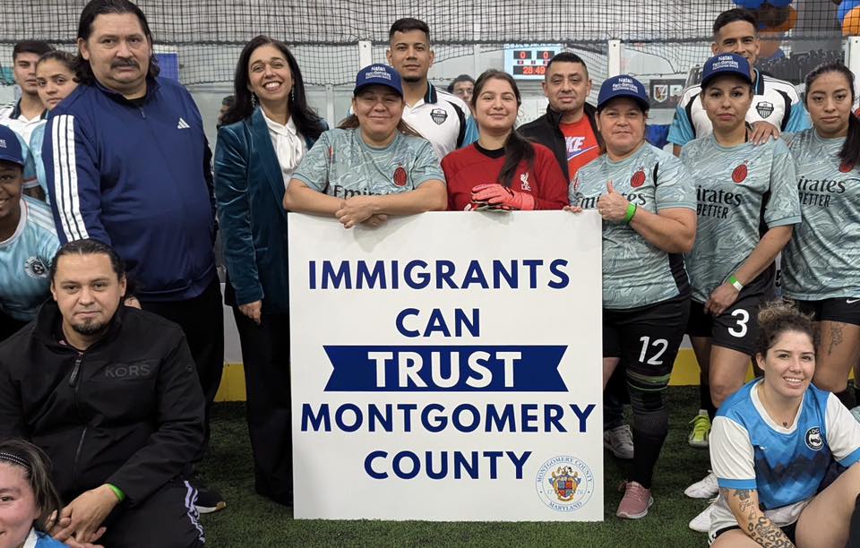 Council President Fani-González stands with soccer players behind a poster reading “Immigrants can trust Montgomery County.”