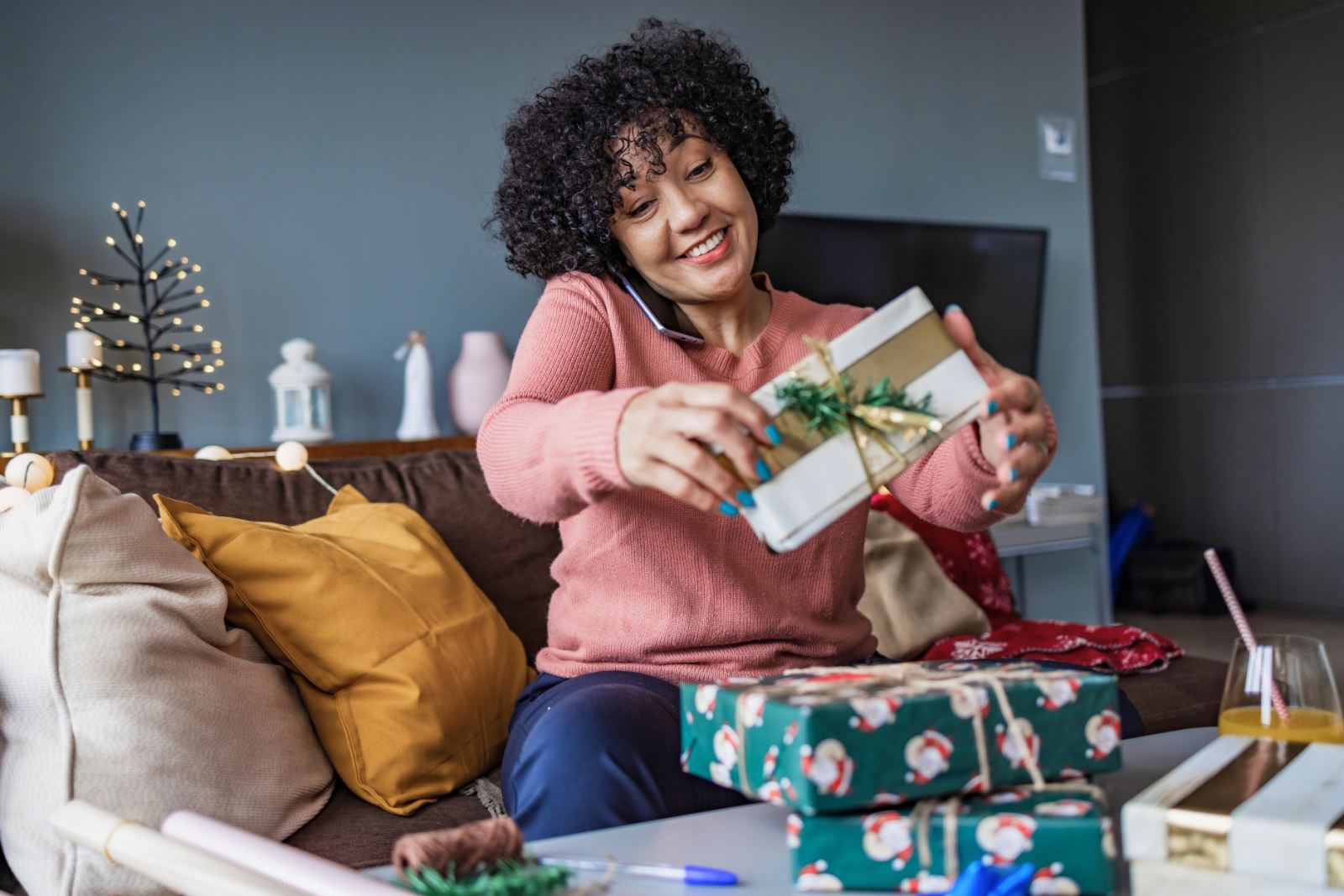 woman on phone wrapping gifts