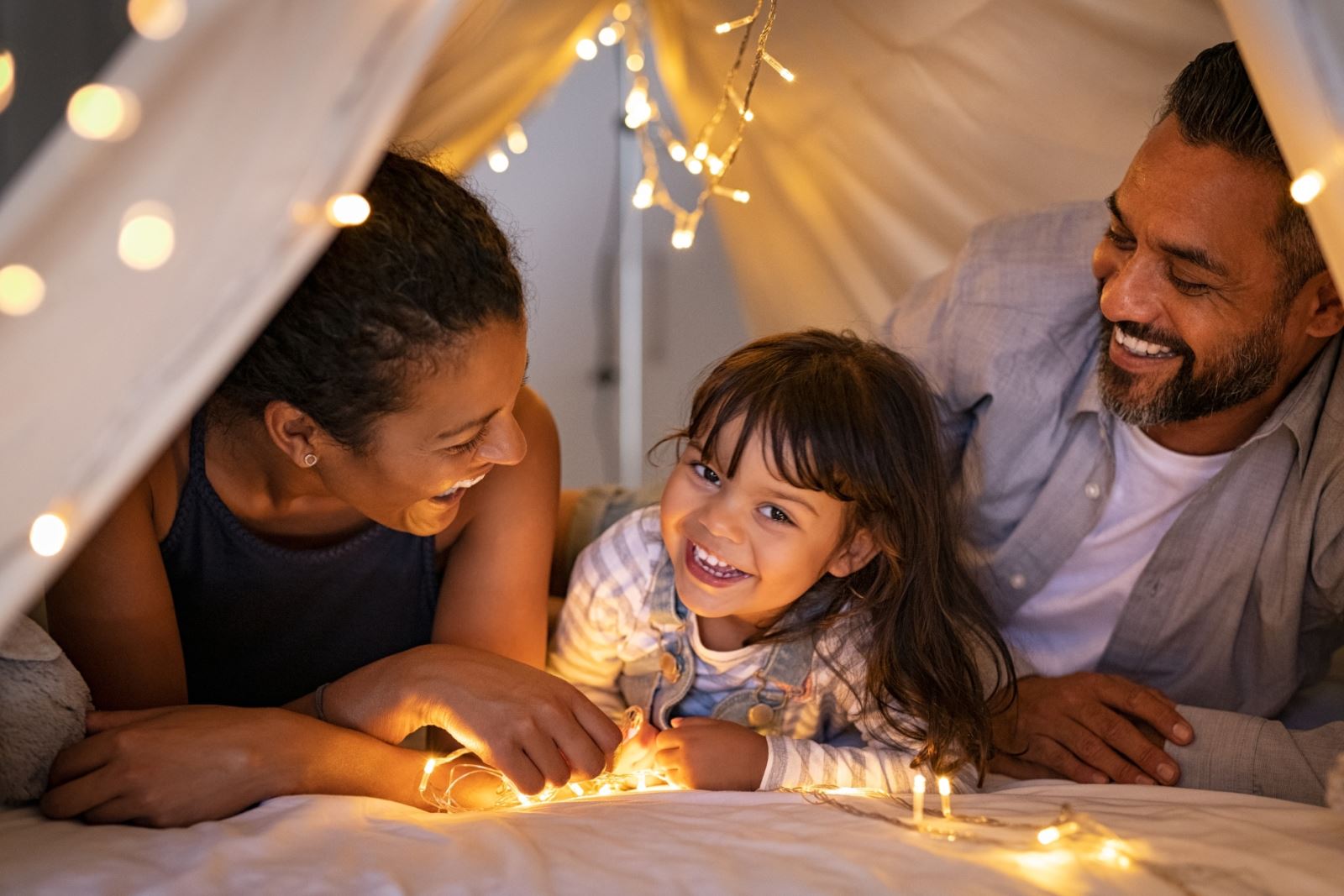 family under a blanket "fort" inside their home