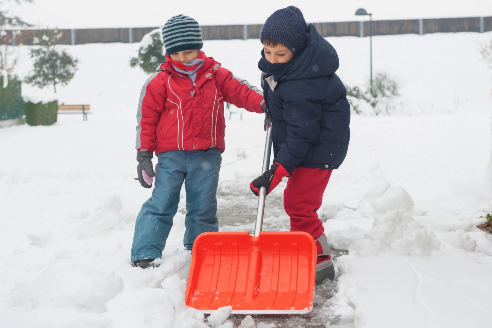 two children shoveling snow