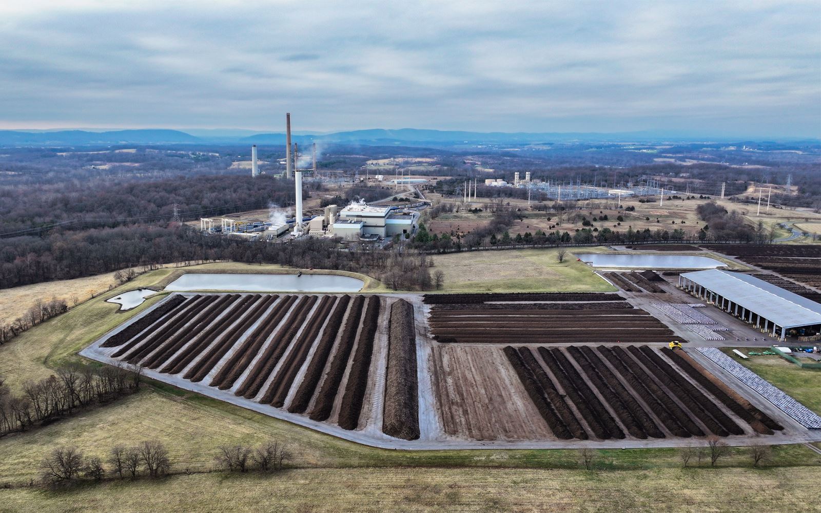 aerial view of yard trim composting rows and emissions stacks from resource recovery facility