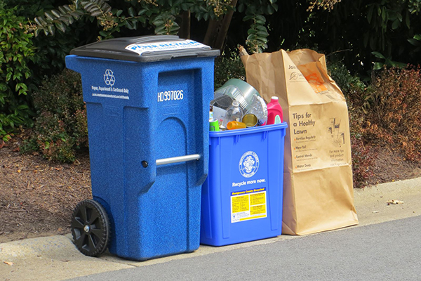 curbside: mixed paper and cardboard recycling cart, blue 22-gallon recycling bin, and yard trim in a paper yard trim bag