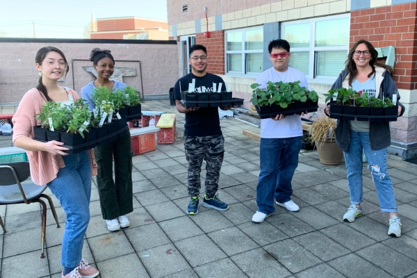students holding plants outdoors