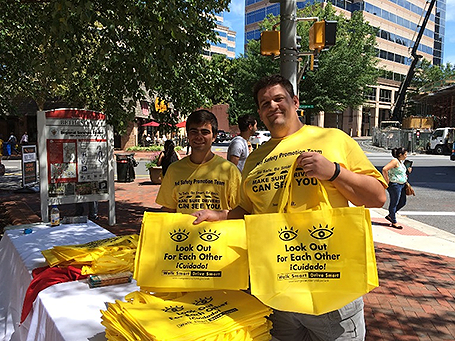Two men holding yellow bags with Look Out For Each Other message.