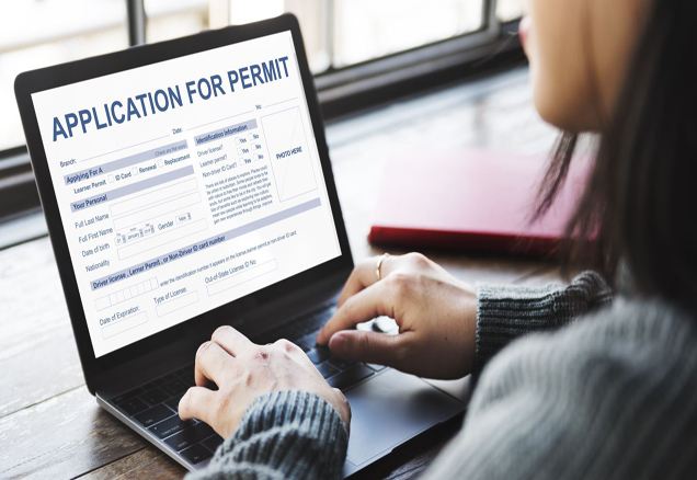 Woman with computer and Permit Application on screen
