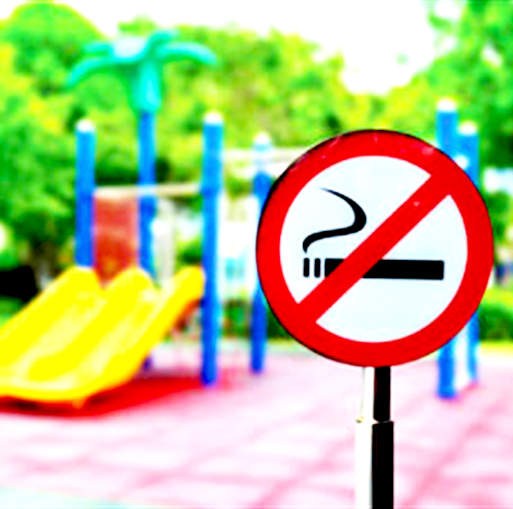 Universal non smoking sign in front of an empty playground