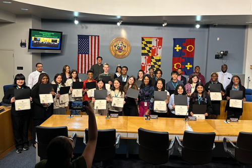 Students being presented with certificates and medals to recognize their achievements