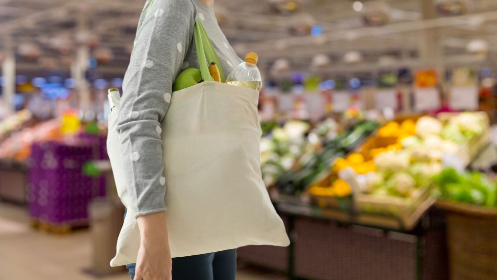 Customer carrying reusable bag at grocery store