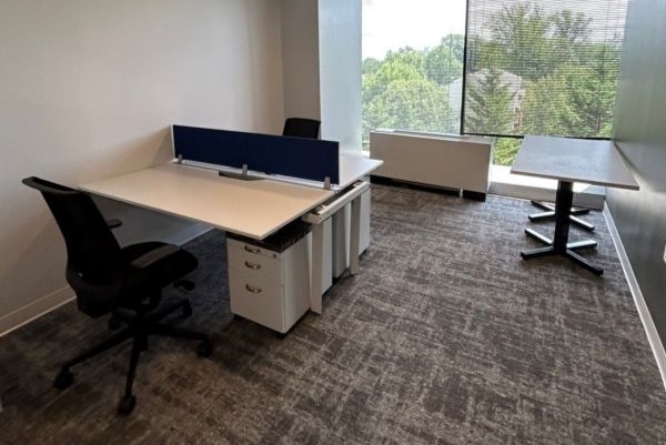 co-working office space with 2 work desks and a window