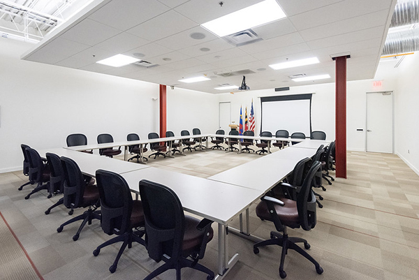 conference room featuring tables set up in a square with chairs around the outside.
