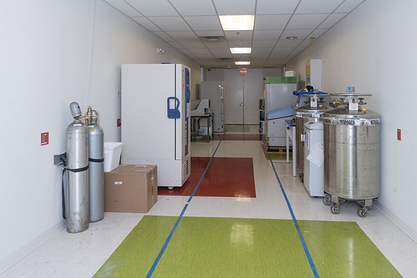 storage area with cylinders, refrigerator, and vats