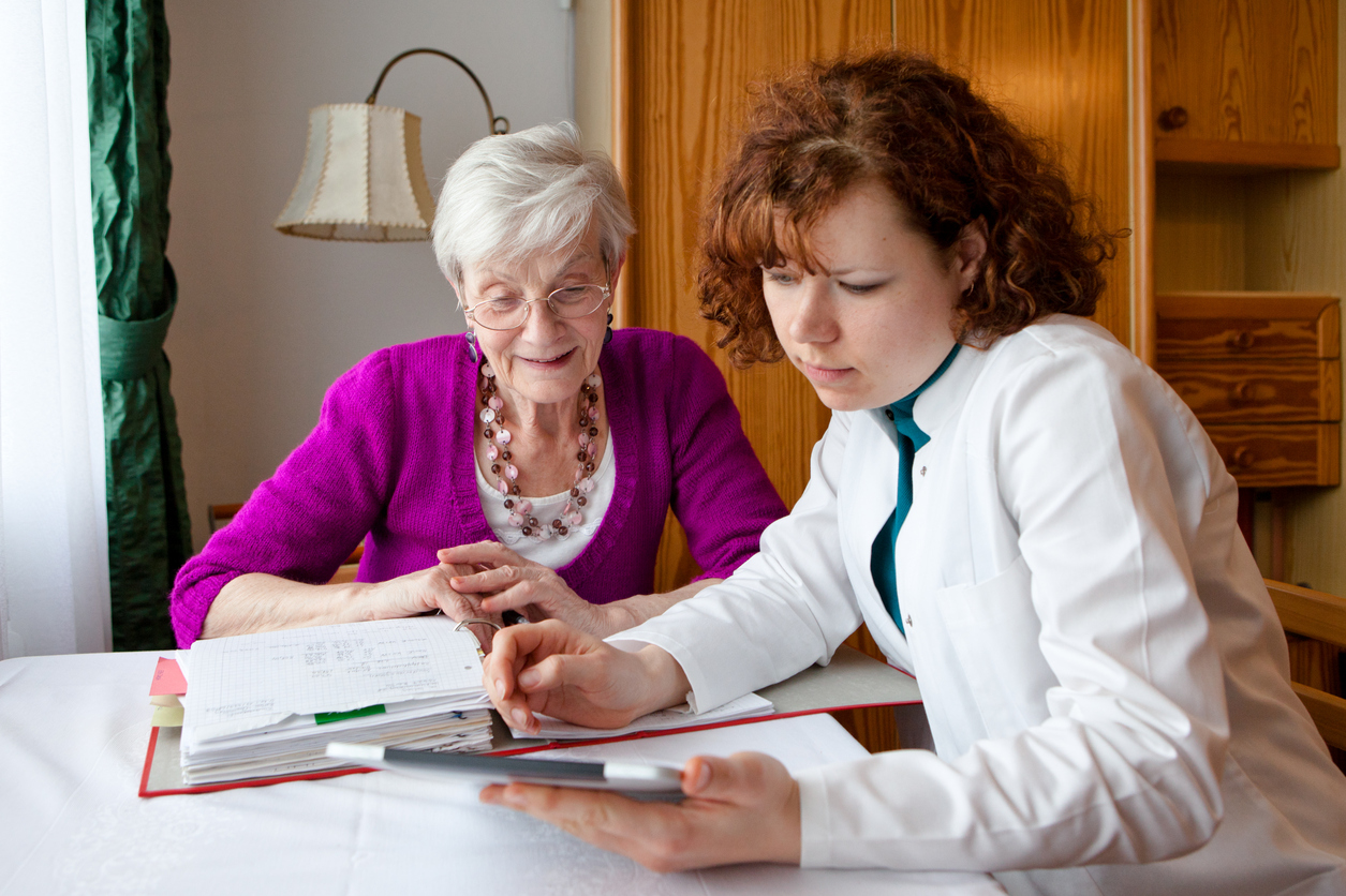 Younger woman helping older woman with paperwork