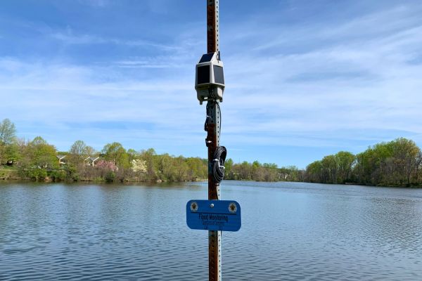 Flood sensor in residentail lake with sign that has the Montgomery County Maryland Seal and reads - flood sensors.