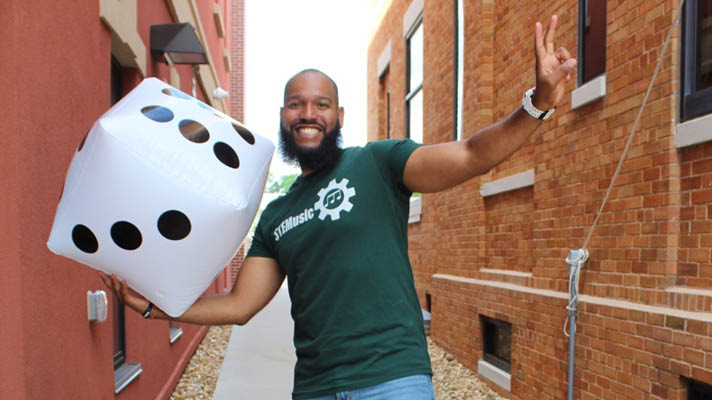presenter Roy Moye holding dice