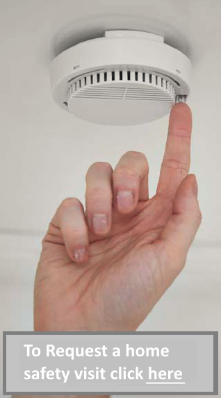 photo of finger pushing a smoke alarm test button