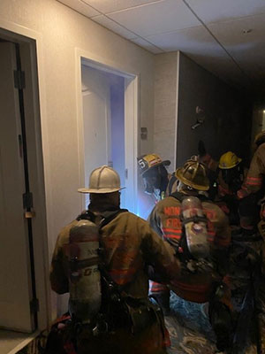 Group of fire fighters outside a smoke filled room