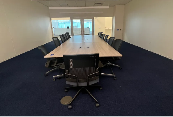 A photo of the conference room with conference tables and chairs.