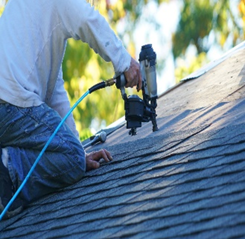 man on a house repairing roof