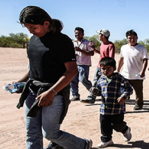 Immigrants walking across dry ground