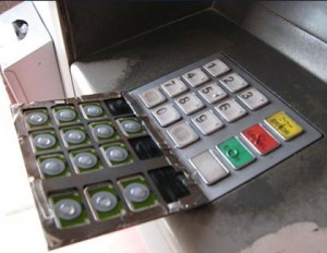 ATM PIN capture overlay device pulled back to reveal the legitimate PIN entry pad.