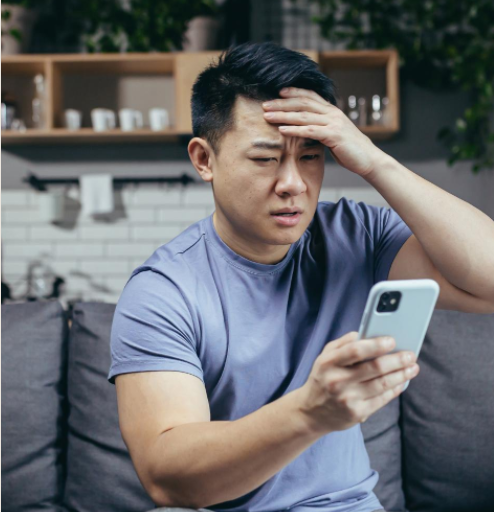 distressed man looking at his cell phone