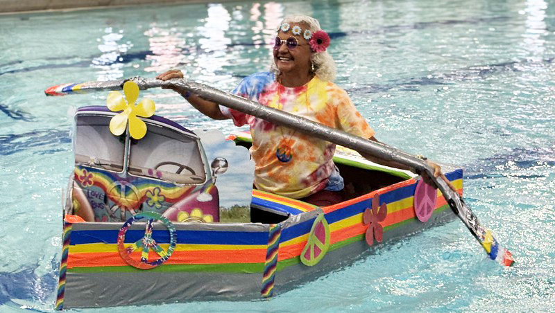 Woman in colorful 70s style cardboard boat at the Senior Cardboard Regatta 2025