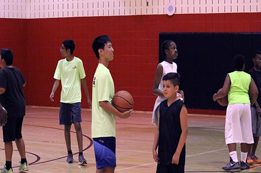 group playing basketball in gym