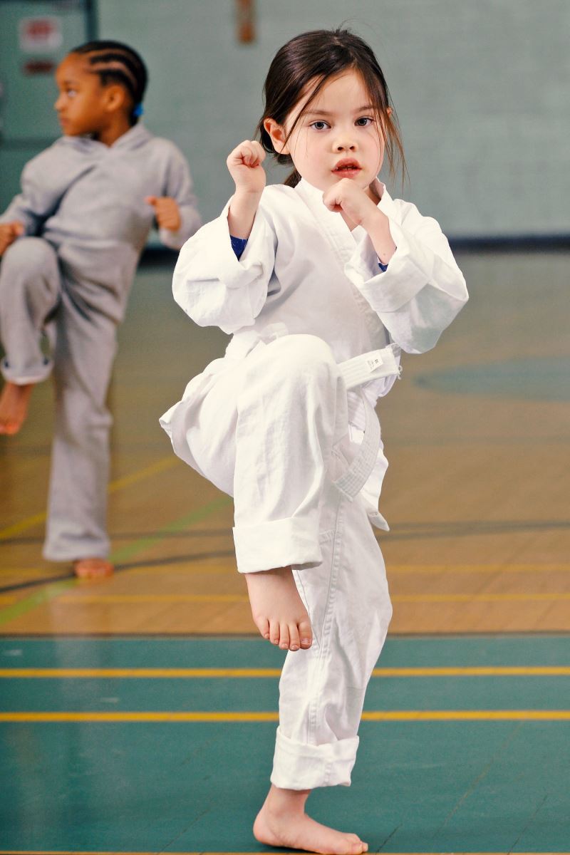 little girl giving a martial arts kick