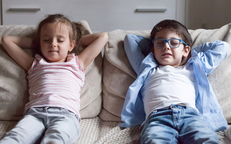 Kids meditating on couch together