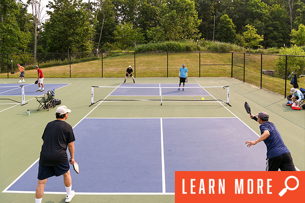 Adults enjoying outdoor pickleball games. View pickleball information.