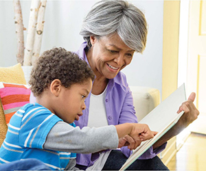 Age friendly Action Plan - Elderly women reading a book to a child.
