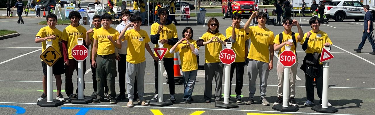 Students showing zero with their hands with Stop and Yield Signs